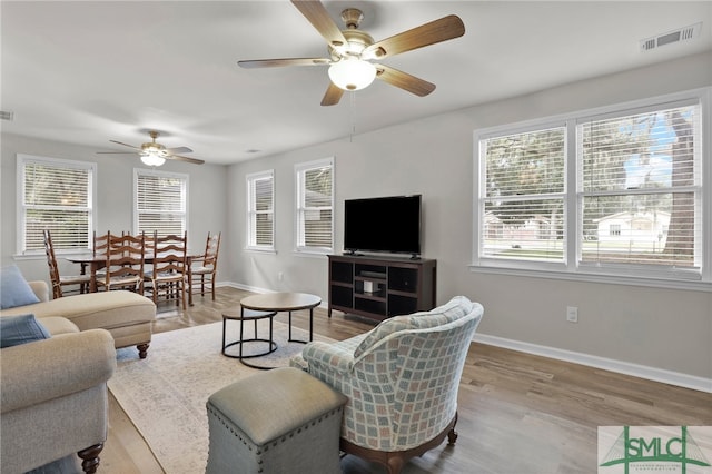 living room featuring ceiling fan and light hardwood / wood-style floors