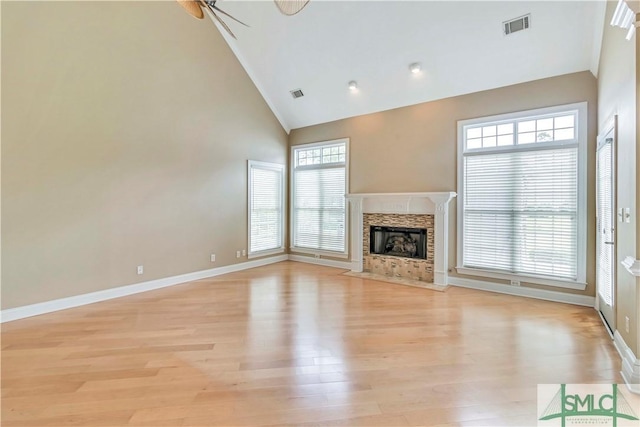 unfurnished living room with ceiling fan, plenty of natural light, and high vaulted ceiling