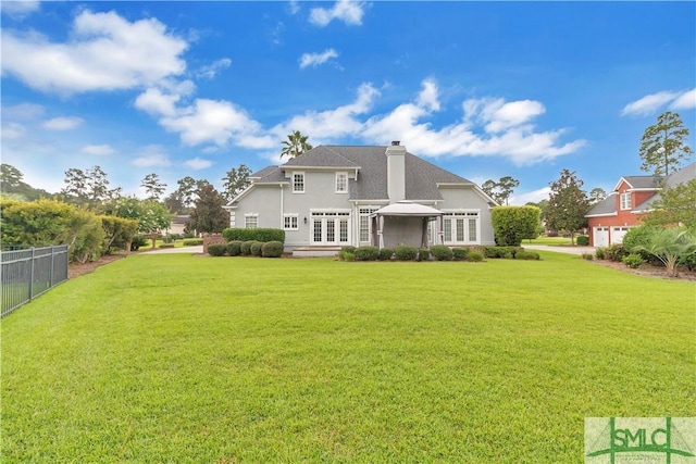 back of house featuring a pergola and a lawn