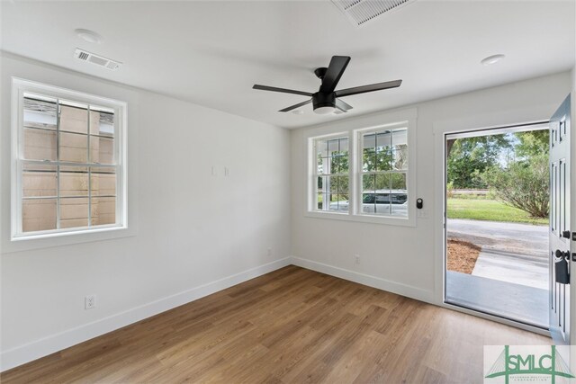 empty room with ceiling fan and light hardwood / wood-style floors