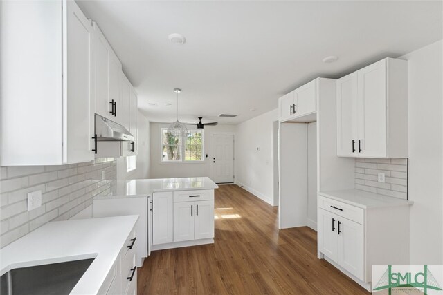 kitchen with white cabinets, ceiling fan, hardwood / wood-style flooring, and decorative backsplash