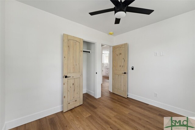 unfurnished bedroom with a closet, ceiling fan, and wood-type flooring