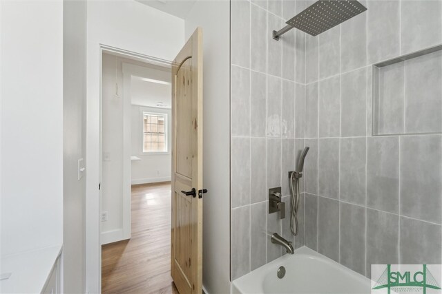 bathroom featuring tiled shower / bath and wood-type flooring