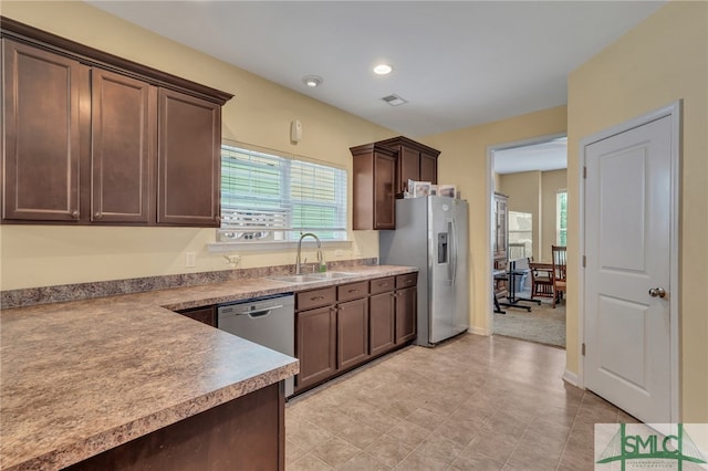 kitchen featuring appliances with stainless steel finishes, dark brown cabinets, and sink