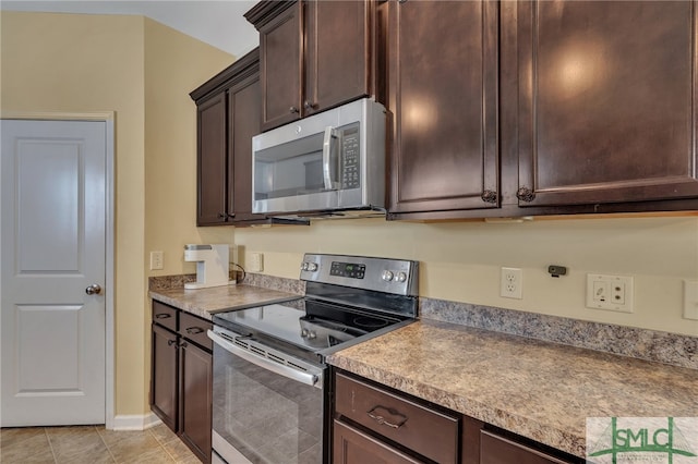 kitchen featuring stainless steel appliances, dark brown cabinetry, and light tile patterned flooring