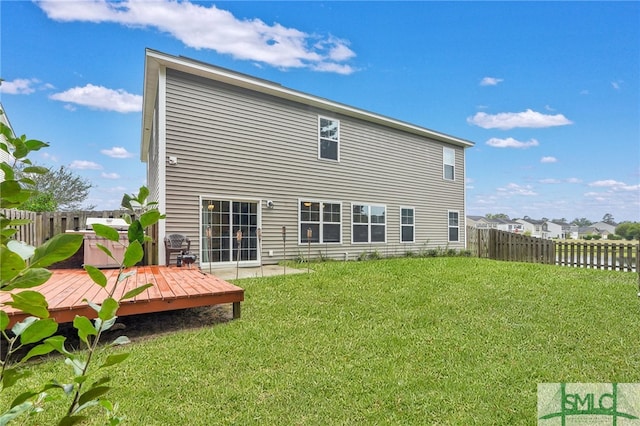 back of house featuring a yard and a wooden deck