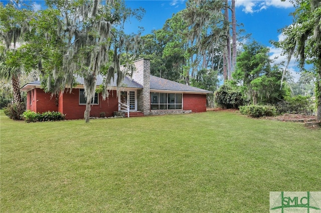 rear view of house featuring a yard