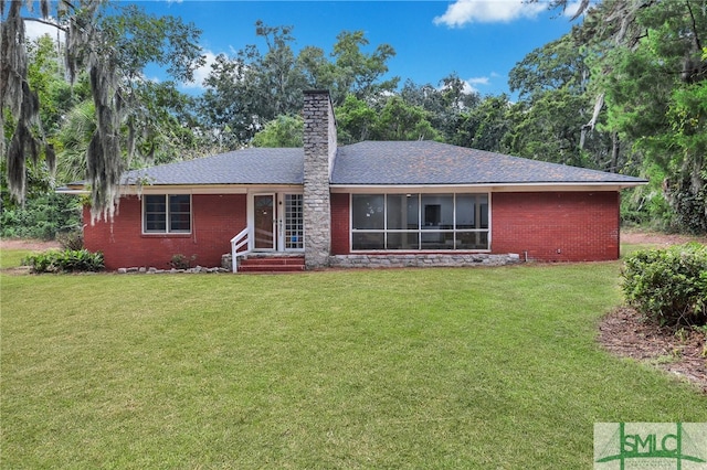 rear view of property featuring a lawn