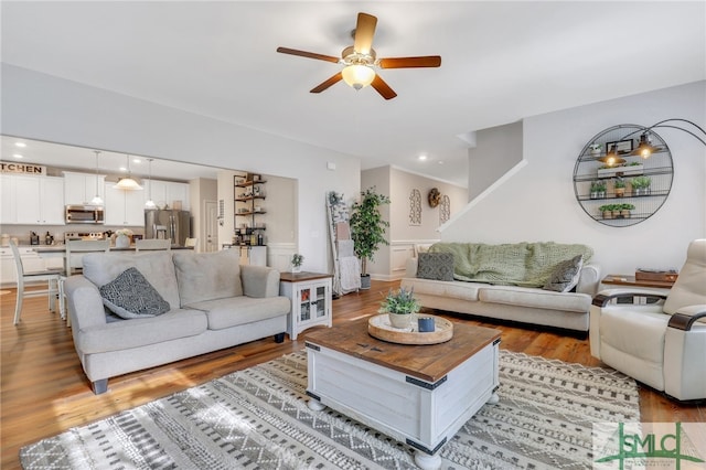 living room featuring light hardwood / wood-style flooring and ceiling fan