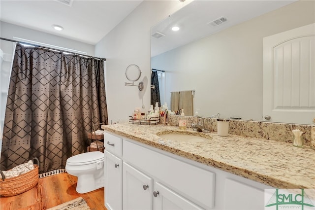 bathroom with vanity, toilet, and wood-type flooring