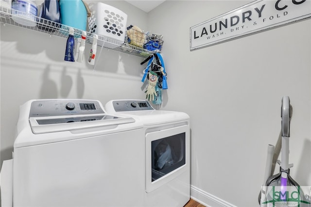 clothes washing area with washer and dryer and hardwood / wood-style flooring