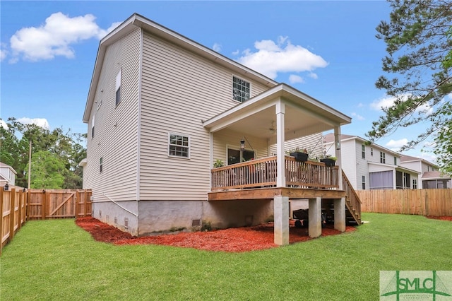 rear view of house with a yard and a wooden deck