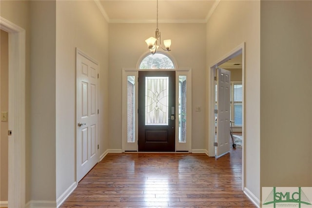 entryway featuring an inviting chandelier, wood-type flooring, and ornamental molding