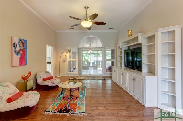 living room with ceiling fan, ornamental molding, and hardwood / wood-style flooring