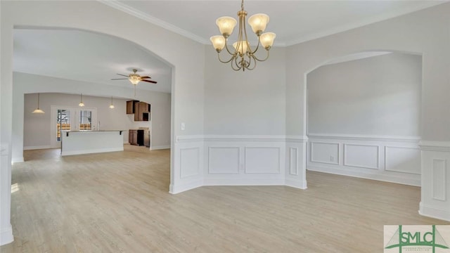 spare room featuring ceiling fan with notable chandelier, crown molding, and light hardwood / wood-style flooring