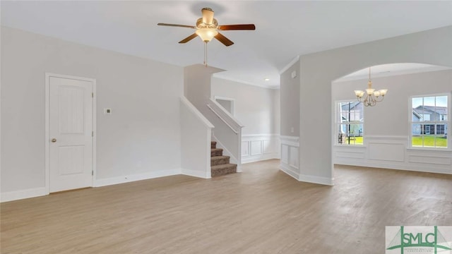 interior space with light wood-type flooring and ceiling fan with notable chandelier