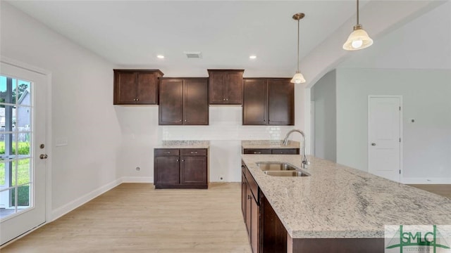 kitchen with light hardwood / wood-style flooring, decorative light fixtures, and sink