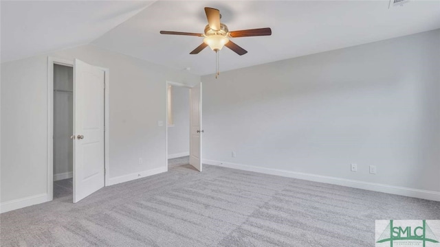 unfurnished bedroom featuring vaulted ceiling, light colored carpet, ceiling fan, and a closet