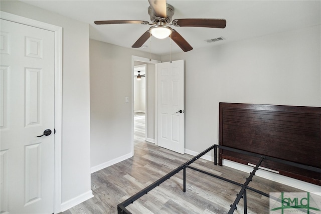 unfurnished bedroom with ceiling fan and light wood-type flooring