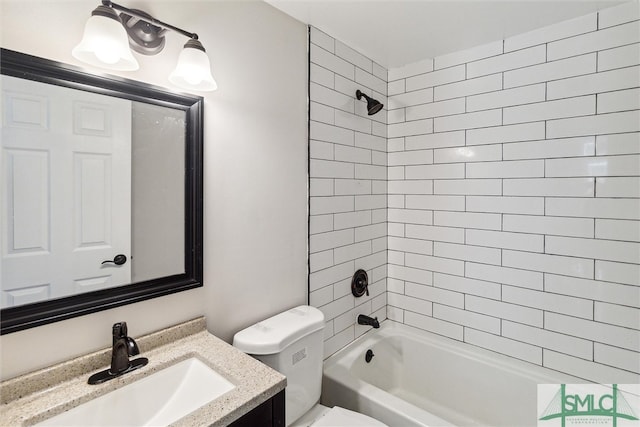 full bathroom featuring tiled shower / bath combo, vanity, and toilet