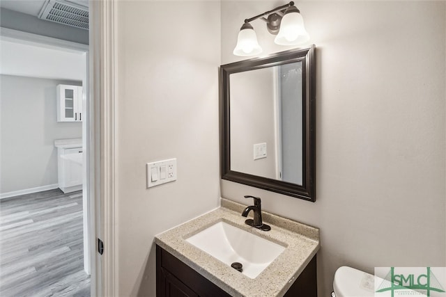 bathroom featuring hardwood / wood-style floors, toilet, and vanity