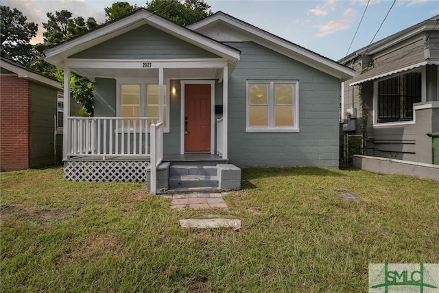 bungalow-style home with covered porch and a front yard