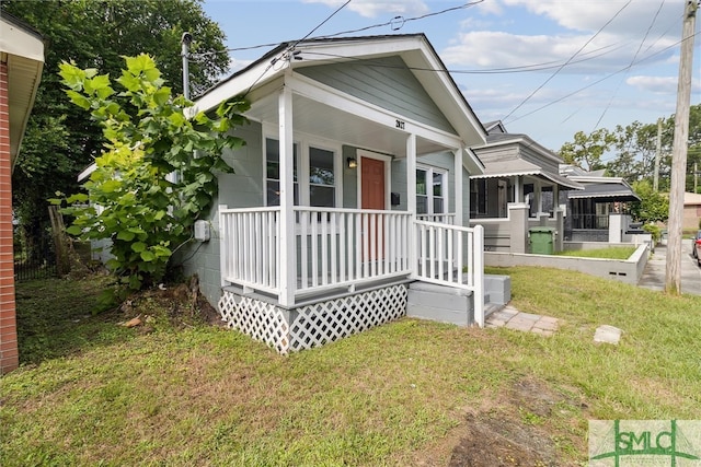 view of front of property featuring covered porch and a front lawn