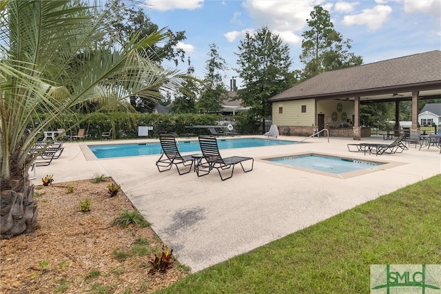 view of swimming pool featuring a patio and a hot tub