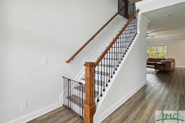 stairs featuring hardwood / wood-style floors and crown molding