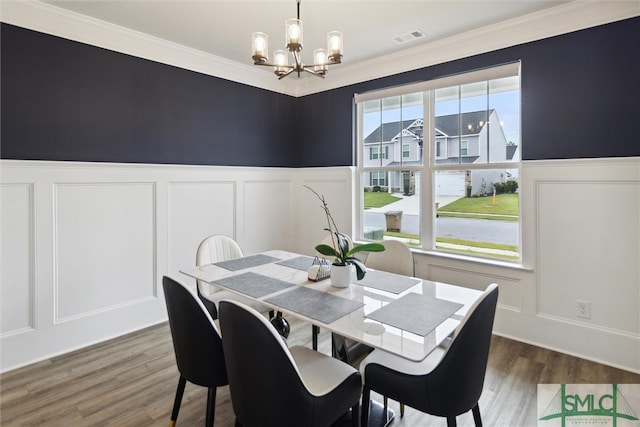 dining area featuring ornamental molding, dark hardwood / wood-style floors, and an inviting chandelier