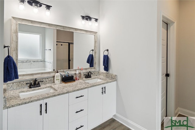 bathroom with hardwood / wood-style floors, independent shower and bath, and vanity