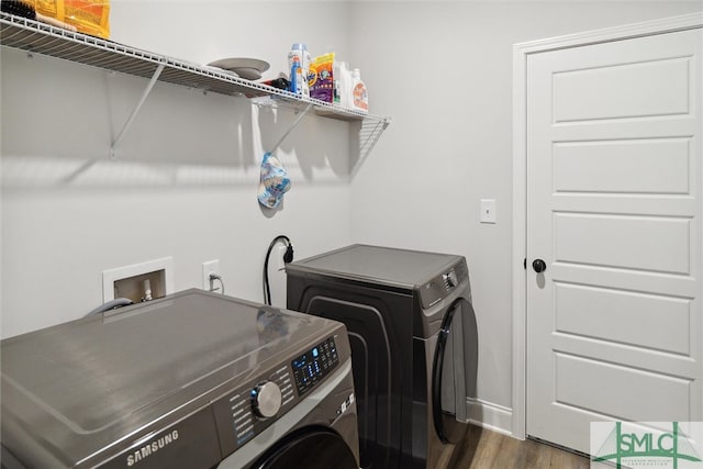 laundry area with dark wood-type flooring and washing machine and clothes dryer