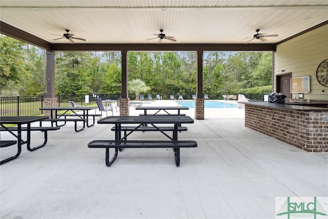 view of patio featuring ceiling fan and a community pool