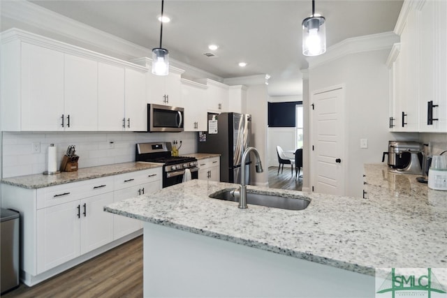 kitchen featuring appliances with stainless steel finishes, white cabinetry, and pendant lighting