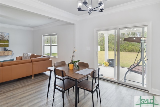 dining room featuring wood-type flooring, plenty of natural light, and ornamental molding