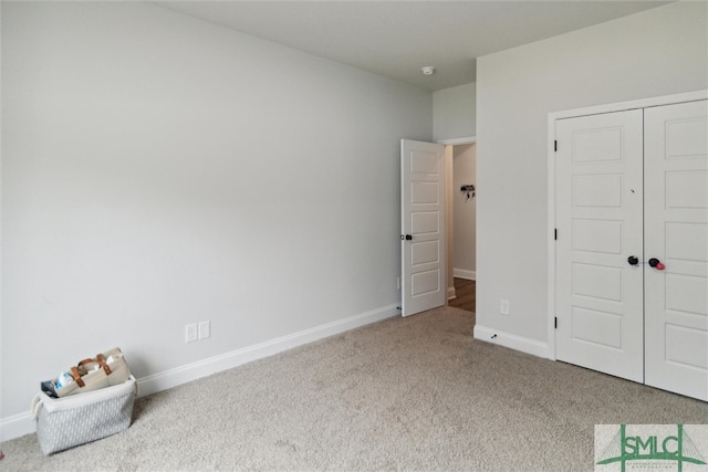 unfurnished bedroom with light colored carpet and a closet