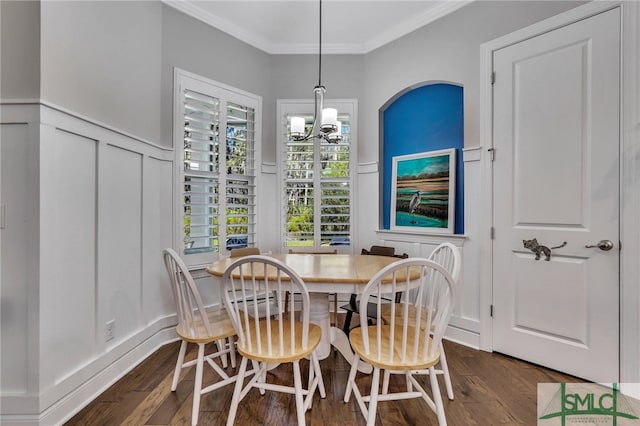 dining room with dark hardwood / wood-style floors, crown molding, and a notable chandelier