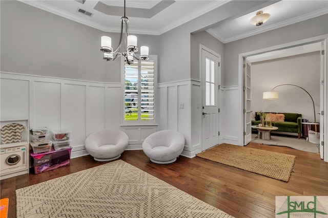 playroom with crown molding, an inviting chandelier, a raised ceiling, and dark hardwood / wood-style flooring