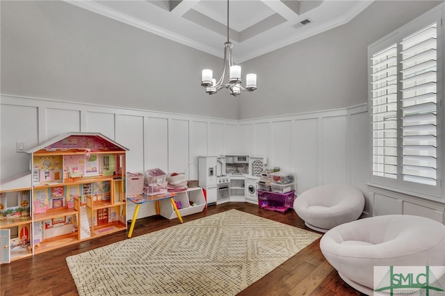 rec room with an inviting chandelier, plenty of natural light, ornamental molding, and dark hardwood / wood-style flooring