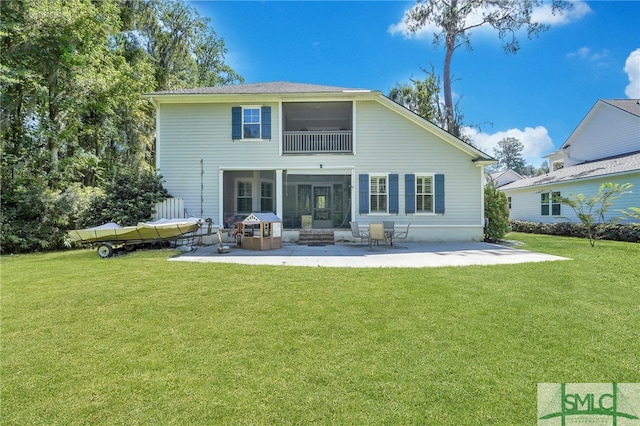 rear view of house with a sunroom, a yard, and a patio