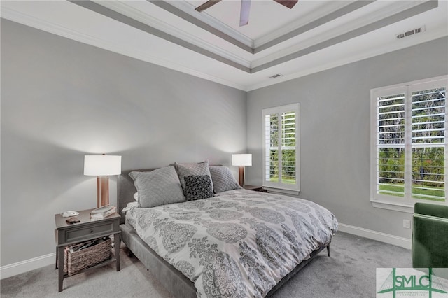 carpeted bedroom featuring crown molding, ceiling fan, and a tray ceiling