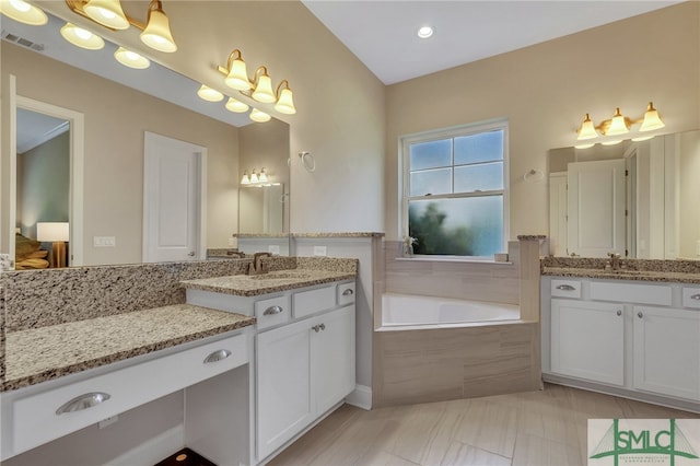 bathroom featuring vanity and a relaxing tiled tub