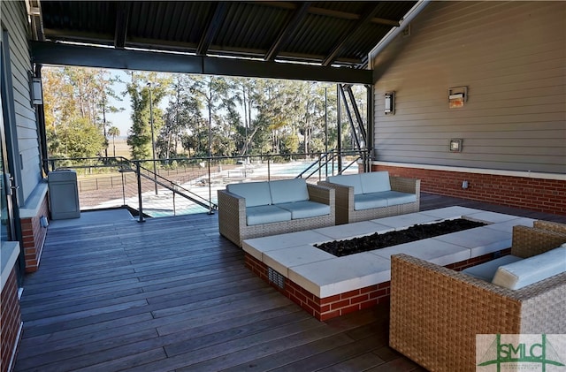 deck with an outdoor living space with a fire pit