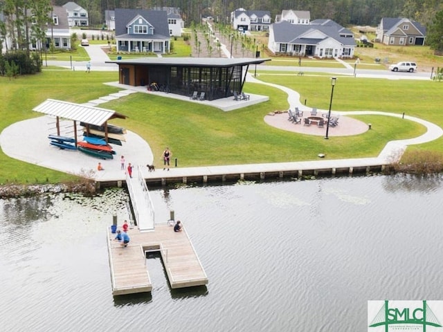 view of dock with a yard and a water view