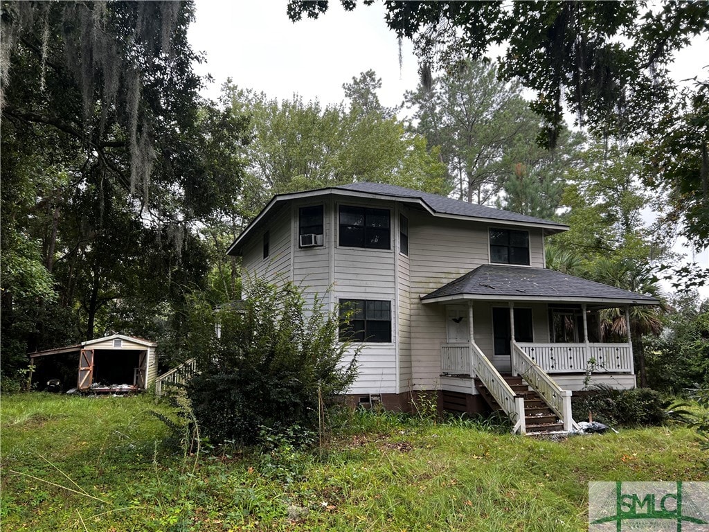 view of front of home with covered porch and a storage unit