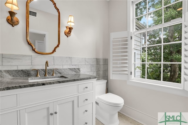 bathroom featuring tile patterned flooring, vanity, a healthy amount of sunlight, and tile walls