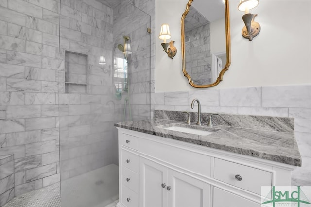 bathroom with vanity, a tile shower, and tile walls