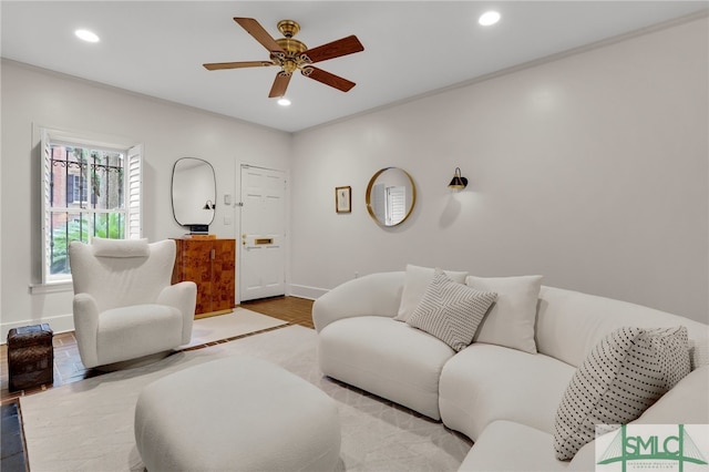 living room featuring light wood-type flooring, ceiling fan, and crown molding