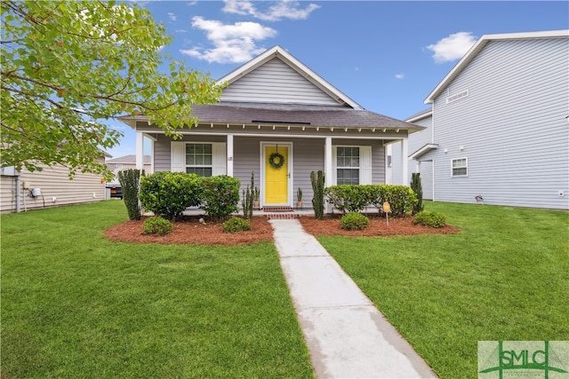 bungalow with covered porch and a front yard