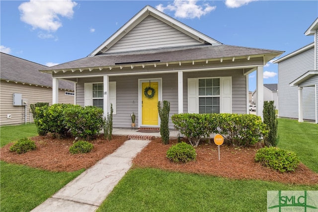 view of front of property with covered porch and a front yard